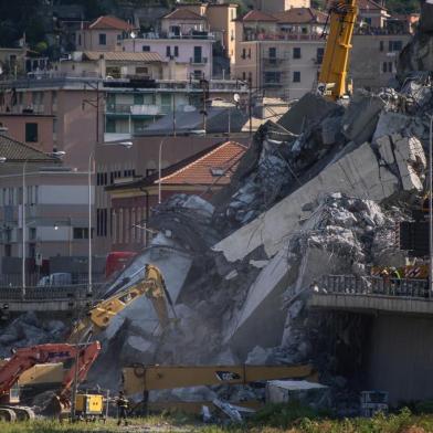 Rescuers work among the rubble and wreckage of the Morandi motorway bridge in Genoa on August 17, 2018, three days after a section collapsed.Rescue workers in Genoa have toiled for a third night in the wreckage of a collapsed bridge, continuing the desperate search for people still missing after the accident, which left at least 38 people dead. Italys populist government intensified its attacks on the viaduct operator amid rising anger over the tragedy and the structural problems that have dogged the decades-old Morandi bridge, which buckled without warning on August 14, sending about 35 cars and several trucks, along with huge chunks of concrete, plunging 45 metres (150 feet) onto railway tracks below. / AFP PHOTO / MARCO BERTORELLO