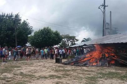 Moradores da cidade fronteiriça brasileira de Pacaraima, em Roraima, queimam pneus e pertences de imigrantes venezuelanos após atacarem os dois principais campos improvisados, levando-os a cruzar a fronteira de volta ao seu país natal em 18 de agosto de 2018. O Brasil enviará tropas para a fronteira com a Venezuela.