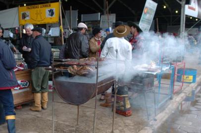 Expointer 2005 no Parque de Exposições Assis Brasil, Esteio. Peões fazem churrasco na frente das baias.