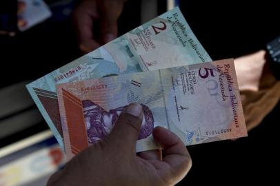 A man shows new five Bolivar-notes in Caracas on August 20, 2018. Caracas is issuing new banknotes after lopping five zeroes off the crippled bolivar, casting a pall of uncertainty over businesses and consumers across the country.Federico PARRA / AFP