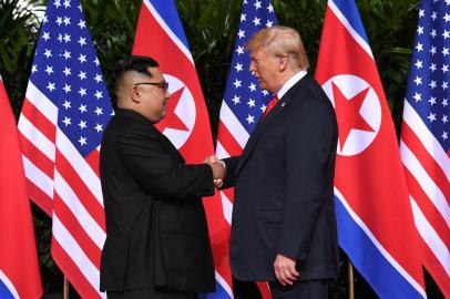 North Korea's leader Kim Jong Un (L) shakes hands with US President Donald Trump (R) at the start of their historic US-North Korea summit, at the Capella Hotel on Sentosa island in Singapore on June 12, 2018.Donald Trump and Kim Jong Un have become on June 12 the first sitting US and North Korean leaders to meet, shake hands and negotiate to end a decades-old nuclear stand-off. / AFP PHOTO / SAUL LOEB