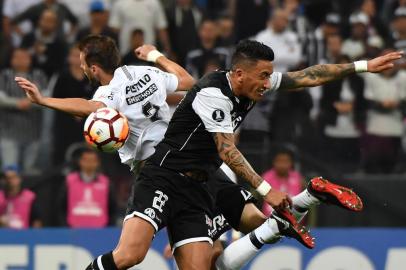 Henrique (L) of Brazil's Corinthians, vies for the ball with Lucas Barrios (R) of Chile's Colo-Colo, during their 2018 Copa Libertadores football match held at Arena Corinthians stadium, in Sao Paulo, Brazil, on August 29, 2018. / AFP PHOTO / NELSON ALMEIDA