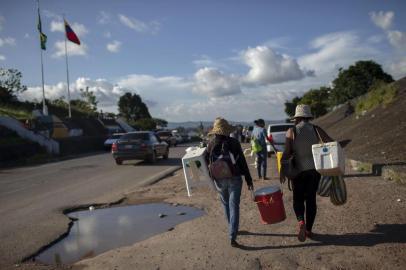  Venezuelan women walk back to their country after a day selling soft drinks and snacks in the Brazilian border in the city of Pacaraima, in Roraima State, on August 21, 2018. Desperate Venezuelans fleeing the countrys crisis continue to cross the Brazilian border, despite the violent anti-migrant riot that took place last week in the border town of Pacaraima. / AFP PHOTO / Mauro PIMENTELEditoria: POLLocal: PacaraimaIndexador: MAURO PIMENTELSecao: migrationFonte: AFPFotógrafo: STF