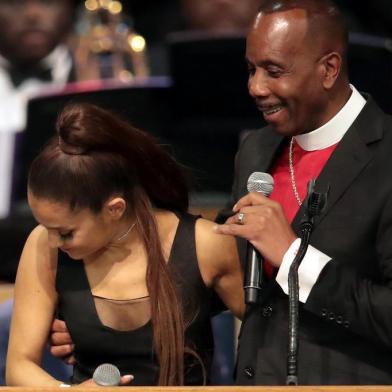 (FILES) In this file photo taken on August 31, 2018 Bishop Charles Ellis chats with Ariana Grande after her performance at the funeral for Aretha Franklin at the Greater Grace Temple on August 31, 2018 in Detroit, Michigan. Bishop Charles H. Ellis III, who officiated the funeral of Aretha Franklin, has apologized for appearing to grope singer Ariana Grande on stage, sparking widespread outrage. It would never be my intention to touch any womans breast. ... I dont know, I guess I put my arm around her, Ellis said in comments to US media confirmed to AFP on September 1, 2018. / AFP PHOTO / GETTY IMAGES NORTH AMERICA / SCOTT OLSON