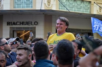  MG - ELEIÇÕES 2018/BOLSONARO - POLÍTICA - O candidato à Presidência da República pelo PSL, Jair Bolsonaro (de camiseta amarela),   após ser esfaqueado durante ato de campanha em Juiz de Fora (MG), nesta quinta-feira, 06.    O presidenciável foi levado para o hospital. Antes do ataque, tumultos, tensão e bate-boca   marcaram a visita de Bolsornaro ao hospital filantrópico da Associação Feminina de   Prevenção e Combate ao Câncer (ASCOMCER) e também um almoço com o candidato em   um hotel em Juiz de Fora, Minas Gerais, hoje.   Brazilian right-wing presidential candidate Jair Bolsonaro gestures after being stabbed in the stomach during a campaign rally in Juiz de Fora, Minas Gerais State, in southern Brazil, on September 6, 2018.Editoria: POLLocal: Juiz de ForaIndexador: RAYSA LEITESecao: electionFonte: AFPFotógrafo: STR