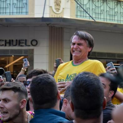  MG - ELEIÇÕES 2018/BOLSONARO - POLÍTICA - O candidato à Presidência da República pelo PSL, Jair Bolsonaro (de camiseta amarela),   após ser esfaqueado durante ato de campanha em Juiz de Fora (MG), nesta quinta-feira, 06.    O presidenciável foi levado para o hospital. Antes do ataque, tumultos, tensão e bate-boca   marcaram a visita de Bolsornaro ao hospital filantrópico da Associação Feminina de   Prevenção e Combate ao Câncer (ASCOMCER) e também um almoço com o candidato em   um hotel em Juiz de Fora, Minas Gerais, hoje.   Brazilian right-wing presidential candidate Jair Bolsonaro gestures after being stabbed in the stomach during a campaign rally in Juiz de Fora, Minas Gerais State, in southern Brazil, on September 6, 2018.Editoria: POLLocal: Juiz de ForaIndexador: RAYSA LEITESecao: electionFonte: AFPFotógrafo: STR