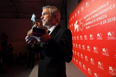 Director Alfonso Cuaron poses during a photocall with the Golden Lion award he received for Best Film for the movie Roma, following the awards ceremony of the 75th Venice Film Festival on September 8, 2018 at Venice Lido.  / AFP PHOTO / Alberto PIZZOLI