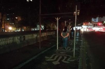 Passageiros esperam ônibus às escuras na Praça Dom Feliciano, no centro de Porto Alegre