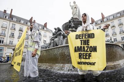  A Greenpeace activist stands in a fountain with a sign which reads  Defend the Amazon reef during a protest in Nantes, western France on September 22, 2018, against the drilling of oils wells by the French company Total in the Amazon Reef off the coast of Brazil.  / AFP PHOTO / SEBASTIEN SALOM GOMISEditoria: ENVLocal: NantesIndexador: SEBASTIEN SALOM GOMISSecao: energy and resourceFonte: AFPFotógrafo: STR