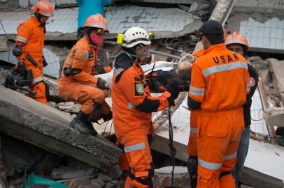  Rescue personnel evacuate earthquake survivor Ida, a food vendor, from the rubble of a collapsed restaurant in Palu, Indonesias Central Sulawesi on September 30, 2018, following the September 28 earthquake and tsunami.The death toll in Indonesias quake-tsunami disaster nearly doubled to more than 800 on September 30, as ill-equipped rescuers struggled to reach scores of trapped victims, health officials resorted to mass burials and desperate residents looted shops for food and water. / AFP PHOTO / BAY ISMOYOEditoria: DISLocal: PaluIndexador: BAY ISMOYOSecao: earthquakeFonte: AFPFotógrafo: STF