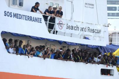  Migrants stand aboard the Aquarius rescue ship as it arrive at Bolier Wharf in Senglea, Malta, on August 15, 2018.The Aquarius, chartered by French group SOS Mediterranee along with Doctors Without Borders (MSF), arrived in Malta on August 15 after EU countries thrashed out a deal to take in the 141 migrants onboard, defusing another diplomatic standoff. The Aquarius had rescued the migrants off the coast of Libya in two separate missions on August 11, only for Italy and Malta to refuse access to their ports. / AFP PHOTO / Matthew MirabelliEditoria: POLLocal: SengleaIndexador: MATTHEW MIRABELLISecao: immigrationFonte: AFPFotógrafo: STR