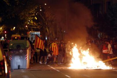 Protesters burn garbage from trash containers after a demonstration held in Barcelona on October 1, 2018 to commemorate the first anniversary of a banned referendum on secession, erupted into riot.A year after a banned referendum on secession from Spain, tens of thousands of Catalan militants piled pressure on the regions separatist government today during an anniversary marked by road and railway line blockades. / AFP PHOTO / Pau Barrena