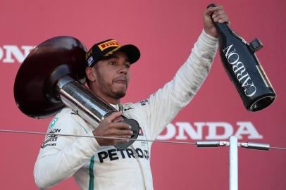 Mercedes British driver Lewis Hamilton celebrates on the podium after his victory in the Formula One Japanese Grand Prix at Suzuka on October 7, 2018. / AFP PHOTO / Behrouz MEHRI