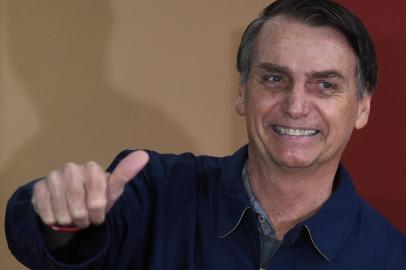  O candidato à Presidência da República pelo PSL, Jair Bolsonaro, vota no primeiro turno das Eleições 2018 na Vila Militar, em Marechal Hermes, na zona norte da cidade, neste domingo, 7.Brazils right-wing presidential candidate for the Social Liberal Party (PSL) Jair Bolsonaro walks in front of the Brazilian flag as he prepares to cast his vote during the general elections, in Rio de Janeiro, Brazil, on October 7, 2018.Polling stations opened in Brazil on Sunday for the most divisive presidential election in the country in years, with far-right lawmaker Jair Bolsonaro the clear favorite in the first round. About 147 million voters are eligible to cast ballots and choose who will rule the worlds eighth biggest economy. New federal and state legislatures will also be elected. / AFP PHOTO / Mauro PIMENTELEditoria: POLLocal: Rio de JaneiroIndexador: MAURO PIMENTELSecao: electionFonte: AFPFotógrafo: STF