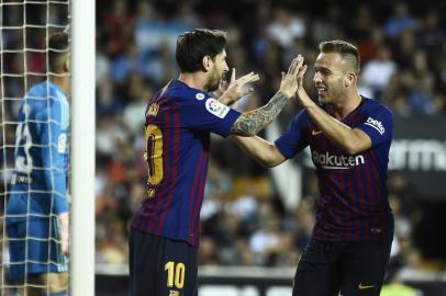 Barcelonas Argentinian forward Lionel Messi celebrates a goal with Barcelonas Brazilian midfielder Arthur during the Spanish league football match between Valencia CF and FC Barcelona at the Mestalla stadium in Valencia on October 7, 2018. / AFP PHOTO / JOSE JORDAN