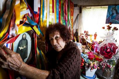 SÃO BORJA, RS, BRASIL, 27-09-2018: Florentina dos Santos Marques, 80 anos, em casa com imagem do Senhor Monge e fitas e flores que recebe pelas graças alcançadas. Ela é conhecida na cidade pelas preces, benzeduras e consultas de tarô e garante ter recebido o chamado do Senhor Monge, um homem misterioso que passou pela Fronteira Oeste na década de 1920. (Foto: Mateus Bruxel / Agência RBS)