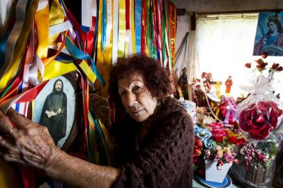 SÃO BORJA, RS, BRASIL, 27-09-2018: Florentina dos Santos Marques, 80 anos, em casa com imagem do Senhor Monge e fitas e flores que recebe pelas graças alcançadas. Ela é conhecida na cidade pelas preces, benzeduras e consultas de tarô e garante ter recebido o chamado do Senhor Monge, um homem misterioso que passou pela Fronteira Oeste na década de 1920. (Foto: Mateus Bruxel / Agência RBS)