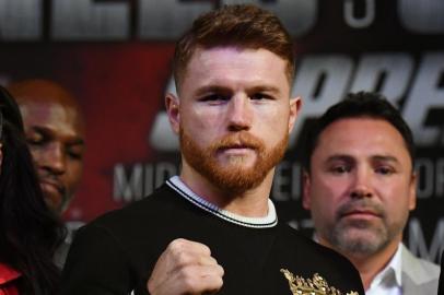 LAS VEGAS, NV - SEPTEMBER 13: Golden Boy Promotions Chairman and CEO Oscar De La Hoya (C) looks on as Canelo Alvarez (L) and WBC, WBA and IBF middleweight champion Gennady Golovkin pose during a news conference at MGM Grand Hotel & Casino on September 12, 2017 in Las Vegas, Nevada. Golovkin will defend his titles against Alvarez at T-Mobile Arena on September 16 in Las Vegas.   Ethan Miller/Getty Images/AFP