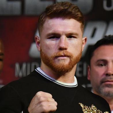 LAS VEGAS, NV - SEPTEMBER 13: Golden Boy Promotions Chairman and CEO Oscar De La Hoya (C) looks on as Canelo Alvarez (L) and WBC, WBA and IBF middleweight champion Gennady Golovkin pose during a news conference at MGM Grand Hotel & Casino on September 12, 2017 in Las Vegas, Nevada. Golovkin will defend his titles against Alvarez at T-Mobile Arena on September 16 in Las Vegas.   Ethan Miller/Getty Images/AFP