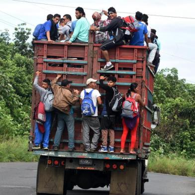  Honduran migrants onboard a truck in direction to Tecun Uman, in the border with Mexico, take part in a caravan heading to the US, in Coatepeque, Quetzaltenango department, on October 19, 2018. - Honduran migrants who have made their way through Central America were gathering at Guatemalas northern border with Mexico on Friday, despite President Donald Trumps threat to deploy the military to stop them entering the United States. (Photo by ORLANDO SIERRA / AFP)Editoria: POLLocal: CoatepequeIndexador: ORLANDO SIERRASecao: migrationFonte: AFPFotógrafo: STR