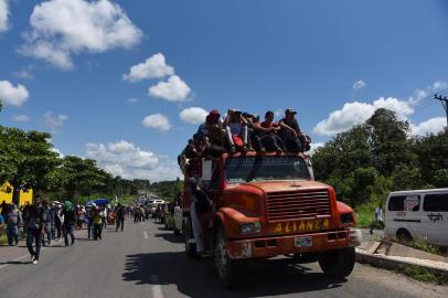 Honduran migrants onboard a truck take part in a caravan heading to the US, in the outskirts of Tapachula, on their way to Huixtla, Chiapas state, Mexico, on October 22, 2018. - President Donald Trump on Monday called the migrant caravan heading toward the US-Mexico border a national emergency, saying he has alerted the US border patrol and military. (Photo by Johan ORDONEZ / AFP)