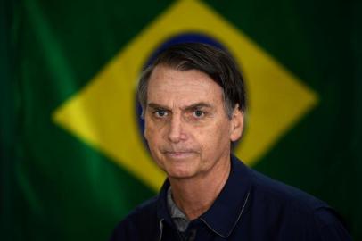  O candidato à Presidência da República pelo PSL, Jair Bolsonaro, vota no primeiro turno das Eleições 2018 na Vila Militar, em Marechal Hermes, na zona norte da cidade, neste domingo, 7.Brazils right-wing presidential candidate for the Social Liberal Party (PSL) Jair Bolsonaro walks in front of the Brazilian flag as he prepares to cast his vote during the general elections, in Rio de Janeiro, Brazil, on October 7, 2018.Polling stations opened in Brazil on Sunday for the most divisive presidential election in the country in years, with far-right lawmaker Jair Bolsonaro the clear favorite in the first round. About 147 million voters are eligible to cast ballots and choose who will rule the worlds eighth biggest economy. New federal and state legislatures will also be elected. / AFP PHOTO / Mauro PIMENTELEditoria: POLLocal: Rio de JaneiroIndexador: MAURO PIMENTELSecao: electionFonte: AFPFotógrafo: STF