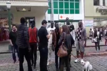 Vídeo mostra confusão envolvendo mulher e ambulantes senegaleses no centro de Caxias do Sul. Ela os acusa de tentarem roubar seu celular e seu cachorro; eles, a acusam de racismo.