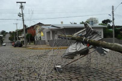  FLORES DA CUNHA, RS, BRASIL, 31/10/2018. Temporal causa destelhamento  de casas e escolas em Flores da Cunha. Escolas do município e a própria sede do Corpo de Bombeiros foram afetadas pela forte chuva que atingiu a região nas últimas horas. Na foto, casas destelhadas na rua John Kennedy esquina com rua Da Paz. Um poste também foi derrubado. (Porthus Junior/Agência RBS)