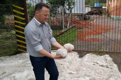 Prefeito Lídio Scortegagna mostra granizo acumulado no travessão Alfredo Chaves, em Flores da Cunha.