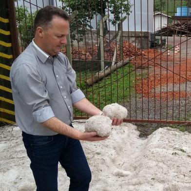 Prefeito Lídio Scortegagna mostra granizo acumulado no travessão Alfredo Chaves, em Flores da Cunha.