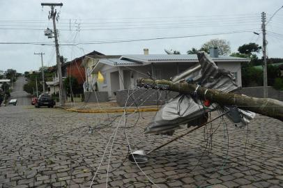  FLORES DA CUNHA, RS, BRASIL, 31/10/2018. Temporal causa destelhamento  de casas e escolas em Flores da Cunha. Escolas do município e a própria sede do Corpo de Bombeiros foram afetadas pela forte chuva que atingiu a região nas últimas horas. Na foto, casas destelhadas na rua John Kennedy esquina com rua Da Paz. Um poste também foi derrubado. (Porthus Junior/Agência RBS)