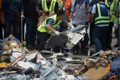 Officials transfer recovered debris from the ill-fated Lion Air flight JT 610 for further examination by Indonesia's National Transportation Safety Committee, at a port in Jakarta, on November 2, 2018. Boeing and US National Transportation Safety Board officials have joined the Indonesian team in sifting through twisted metal plane parts and piles of passengers' torn clothing, shoes, wallets and phones, as authorities analysed black box data that may explain why the new plane plummeted into the Java Sea, killing 189 people. BAY ISMOYO / AFP