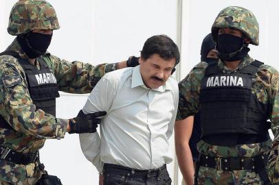 FILES-MEXICO-DRUGS-CHAPO GUZMAN-ARREST(FILES) Mexican drug trafficker Joaquin Guzman Loera aka el Chapo Guzman (C), is escorted by marines as he is presented to the press on February 22, 2014 in Mexico City. Mexican authorities have recaptured fugitive drug kingpin Joaquin El Chapo Guzman, six months after his prison break, President Enrique Pena Nieto said on January 8, 2016. AFP PHOTO/RONALDO SCHEMIDT