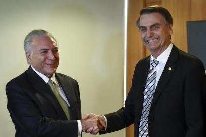 Brazilian President Michel Temer (L) shakes hands with Brazilian president-elect Jair Bolsonaro during a meeting in Brasilia on November 7, 2018. (Photo by EVARISTO SA / AFP)