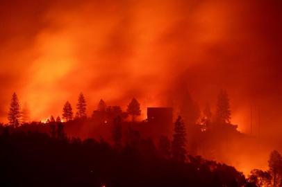 Flames from the Camp fire burn near a home atop a ridge near Big Bend, California, on November 10, 2018. - The death toll from the most destructive fire to hit California rose to 23 on November 10 as rescue workers recovered more bodies of people killed by the devastating blaze. Ten of the bodies were found in the town of Paradise while four were discovered in the Concow area, both in Butte County. (Photo by Josh Edelson / AFP)