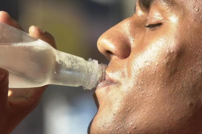 Forte Calor em Porto Alegre durante o outono. Pessoa bebendo água mineral.#Máquina: D1-5021709calor seca  água_mineral  verão em abril  outono quente