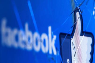 (FILES) In this file photo taken on May 16, 2018 shows the logo of the social network Facebook on a broken screen of a mobile phone. - Facebook said Thursday, November 15, 2018 it was severing ties with a political consultancy that sought to discredit critics of the social networking giant using questionable campaign-style tactics. The California-based company's announcement followed a lengthy New York Times investigation detailing Facebook's struggles with its image as it came under scrutiny for its handling of Russian-led misinformation efforts. Facebook said in a statement that "we ended our contract" with Definers Public Affairs, which specializes in opposition research and, according to the Times, sought to link anti-Facebook efforts to financier George Soros. But Facebook disputed claims that it used the firm in a nefarious way. (Photo by JOEL SAGET / AFP)