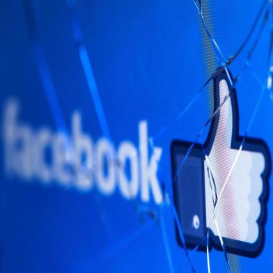 (FILES) In this file photo taken on May 16, 2018 shows the logo of the social network Facebook on a broken screen of a mobile phone. - Facebook said Thursday, November 15, 2018 it was severing ties with a political consultancy that sought to discredit critics of the social networking giant using questionable campaign-style tactics. The California-based company's announcement followed a lengthy New York Times investigation detailing Facebook's struggles with its image as it came under scrutiny for its handling of Russian-led misinformation efforts. Facebook said in a statement that "we ended our contract" with Definers Public Affairs, which specializes in opposition research and, according to the Times, sought to link anti-Facebook efforts to financier George Soros. But Facebook disputed claims that it used the firm in a nefarious way. (Photo by JOEL SAGET / AFP)