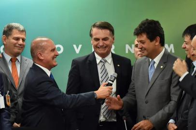 Futuro ministro da Casa Civil, Onyx Lorenzoni (esq.), entrega microfone a Luiz Henrique Mandetta (dir.), anunciado como novo ministro da Saúde no governo de Jair Bolsonaro (centro)