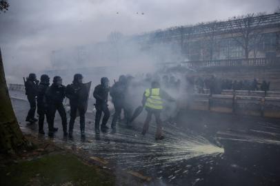 Yellow Vests (Gilets Jaunes in French) protesters clash with riot police forces against rising oil prices and living costs, in the French capital Paris on December 1, 2018. The yellow vest or Gilets jaunes movement is named after the high-visibility jackets which motorists are required to carry in their cars. The movement, organised through social media, has steadfastly refused to align with any political party or trade union and includes many pensioners and has been most active in small urban and rural areas where it has blocked roads, closed motorway toll booths, and even walled up the entrance to tax offices.