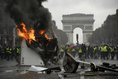 A truck burns during a protest of Yellow vests (Gilets jaunes) against rising oil prices and living costs near the Arc of Triomphe on the Champs Elysees in Paris, on November 24, 2018. - Police fired tear gas and water cannon on November 24 in central Paris against yellow vest protesters demanding French President Emmanuel Macron roll back tax hikes on motor fuel. (Photo by Bertrand GUAY / AFP)