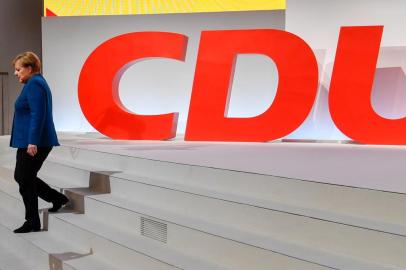 German Chancellor and leader of the Christian Democratic Union (CDU) Angela Merkel leaves the stage in front of a huge CDU logo after her speech at a party congress of Germanys conservative Christian Democratic Union (CDU) party on December 7, 2018 at a fair hall in Hamburg, northern Germany. - German Chancellor Angela Merkel will hand off leadership of her party after nearly two decades at the helm, with the race wide open between a loyal deputy and a longtime rival. (Photo by John MACDOUGALL / AFP)