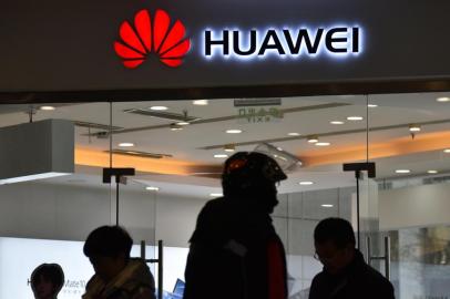  This photo taken on December 10, 2018 shows people walking past a Huawei store in Beijing. - Chinas ambitious drive to dominate next-generation 5G technology faces a sudden reality check as fears spread that telecom companies like Huawei could be proxies for Beijings intrusive security apparatus. (Photo by Greg Baker / AFP) / TO GO WITH China-US-telecommunication-diplomacy-Huawei-5G, FOCUS by Dan MartinEditoria: FINLocal: BeijingIndexador: GREG BAKERSecao: telecommunication serviceFonte: AFPFotógrafo: STF