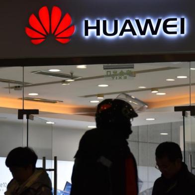  This photo taken on December 10, 2018 shows people walking past a Huawei store in Beijing. - Chinas ambitious drive to dominate next-generation 5G technology faces a sudden reality check as fears spread that telecom companies like Huawei could be proxies for Beijings intrusive security apparatus. (Photo by Greg Baker / AFP) / TO GO WITH China-US-telecommunication-diplomacy-Huawei-5G, FOCUS by Dan MartinEditoria: FINLocal: BeijingIndexador: GREG BAKERSecao: telecommunication serviceFonte: AFPFotógrafo: STF