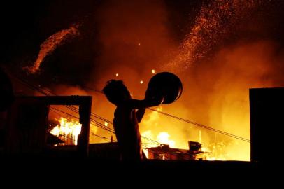 INCÊNDIO DE GRANDES PROPORÇÕES DESTRÓI CERCA DE 600 CASAS EM MANAUS.AM - INCÊNDIO-CASAS-MANAUS - GERAL - Moradores tentam apagar incêndio de grandes proporções que destrói cerca de 600 casas no bairro Educandos, em Manaus (AM), no final da noite desta segunda-feira (17), deixando milhares de moradores desabrigados. Cerca de 100 bombeiros trabalharam durante 4 horas para controlar o incêndio e por diversas vezes ficaram sem água nas mangueiras. Quatro pessoas ficaram feridas e três escolas nas proximidades foram disponibilizadas para receber os desabrigados. 17/12/2018 - Foto: EDMAR BARROS/FUTURA PRESS/FUTURA PRESS/ESTADÃO CONTEÚDOEditoria: GERALLocal: MANAUSIndexador: EDMAR BARROSFotógrafo: FUTURA PRESS