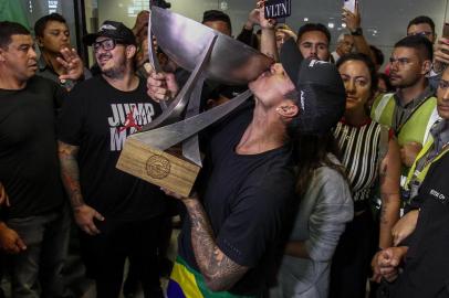 Brazils Gabriel Medina is surrounded by fans upon landing at Guarulhos International Airport in Sao Paulo, Brazil on December 22, 2018 after securing the second World Title Billabong Pipe Masters by winning on the north shore of Oahu in Hawaii on December 17. (Photo by Miguel SCHINCARIOL / AFP)