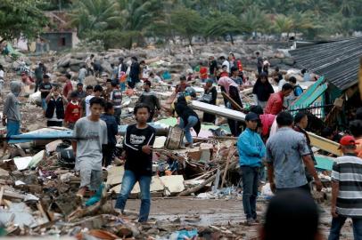 Rescuers and residents look for survivors along the coast in South Lampung on South Sumatra on December 23, 2018, after the area was hit by a tsunami on December 22 following an eruption of the Anak Krakatoa volcano. - A volcano-triggered tsunami has left at least 222 people dead and hundreds more injured after slamming without warning into beaches around Indonesias Sunda Strait, officials said on December 23, voicing fears that the toll would rise further. (Photo by Ferdi Awed / AFP)