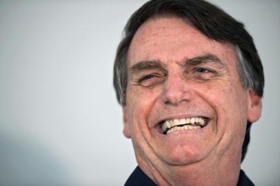 Brazilian far-right presidential candidate Jair Bolsonaro gestures as he talks to the press in Rio de Janeiro, Brazil on October 25, 2018. - The presidential runoff election takes place on October 28 in Brazil. (Photo by CARL DE SOUZA / AFP)