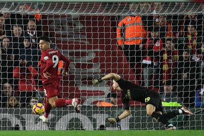 Liverpools Brazilian midfielder Roberto Firmino (L) scores his teams first goal during the English Premier League football match between Liverpool and Arsenal at Anfield in Liverpool, north west England on December 29, 2018. (Photo by Paul ELLIS / AFP) / RESTRICTED TO EDITORIAL USE. No use with unauthorized audio, video, data, fixture lists, club/league logos or live services. Online in-match use limited to 120 images. An additional 40 images may be used in extra time. No video emulation. Social media in-match use limited to 120 images. An additional 40 images may be used in extra time. No use in betting publications, games or single club/league/player publications. / 