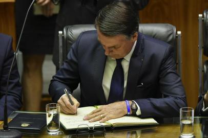  Brazils President-elect Jair Bolsonaro signs a document at the Congress before he is sworn in as Brazils new president, in Brasilia on January 1, 2019. - Bolsonaro takes office with promises to radically change the path taken by Latin Americas biggest country by trashing decades of centre-left policies. (Photo by NELSON ALMEIDA / AFP)Editoria: POLLocal: BrasíliaIndexador: NELSON ALMEIDASecao: governmentFonte: AFPFotógrafo: STF